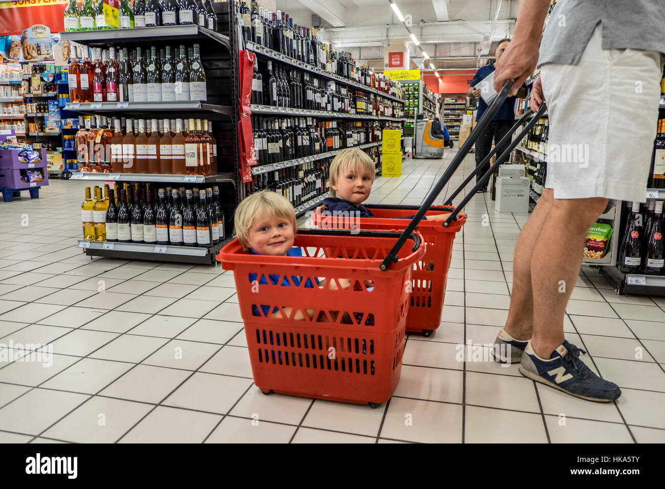 Children is sitting in shopping carts. Stock Photo