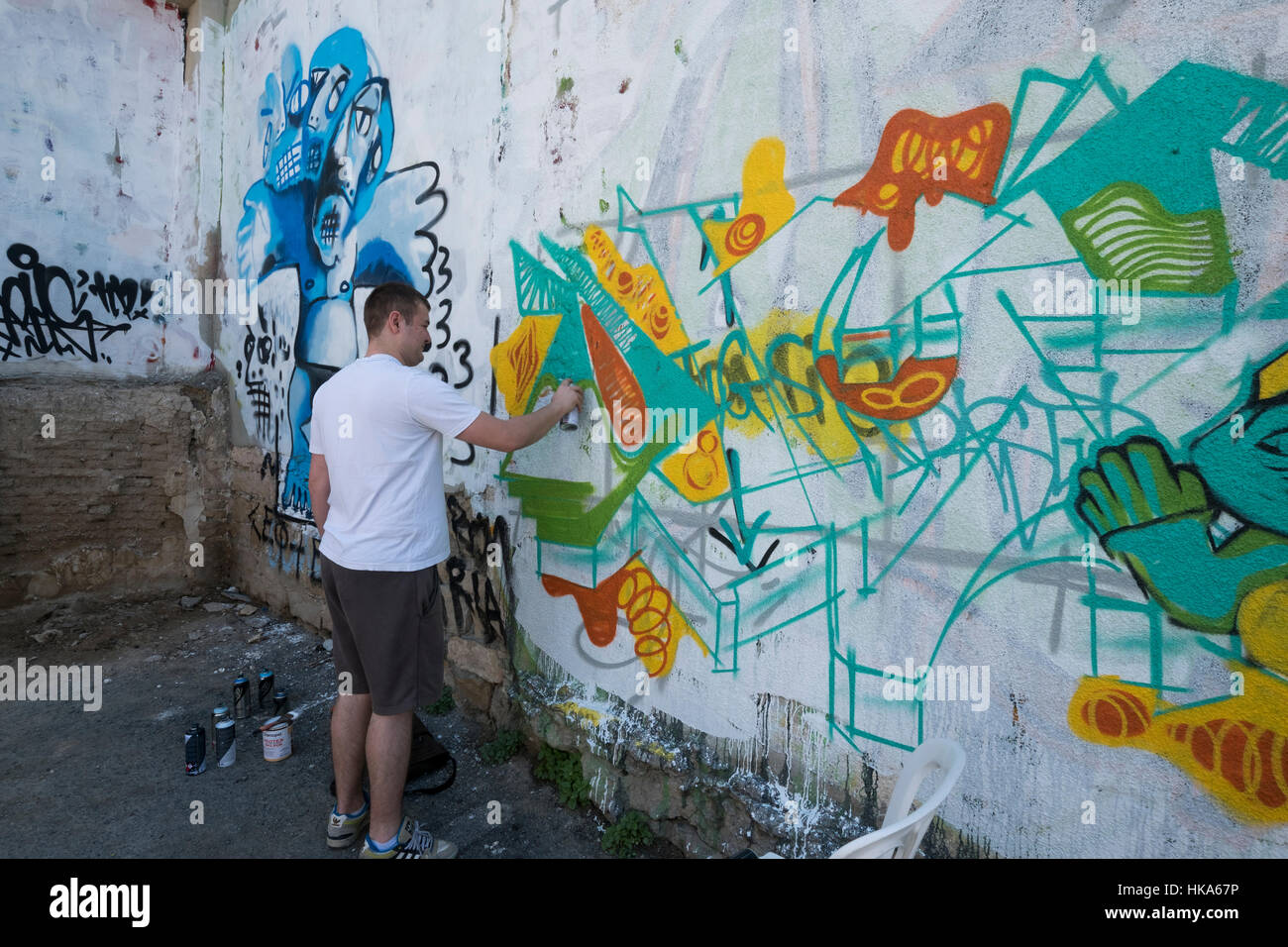 A man painting graffiti on the wall, Limassol, Cyprus. Stock Photo