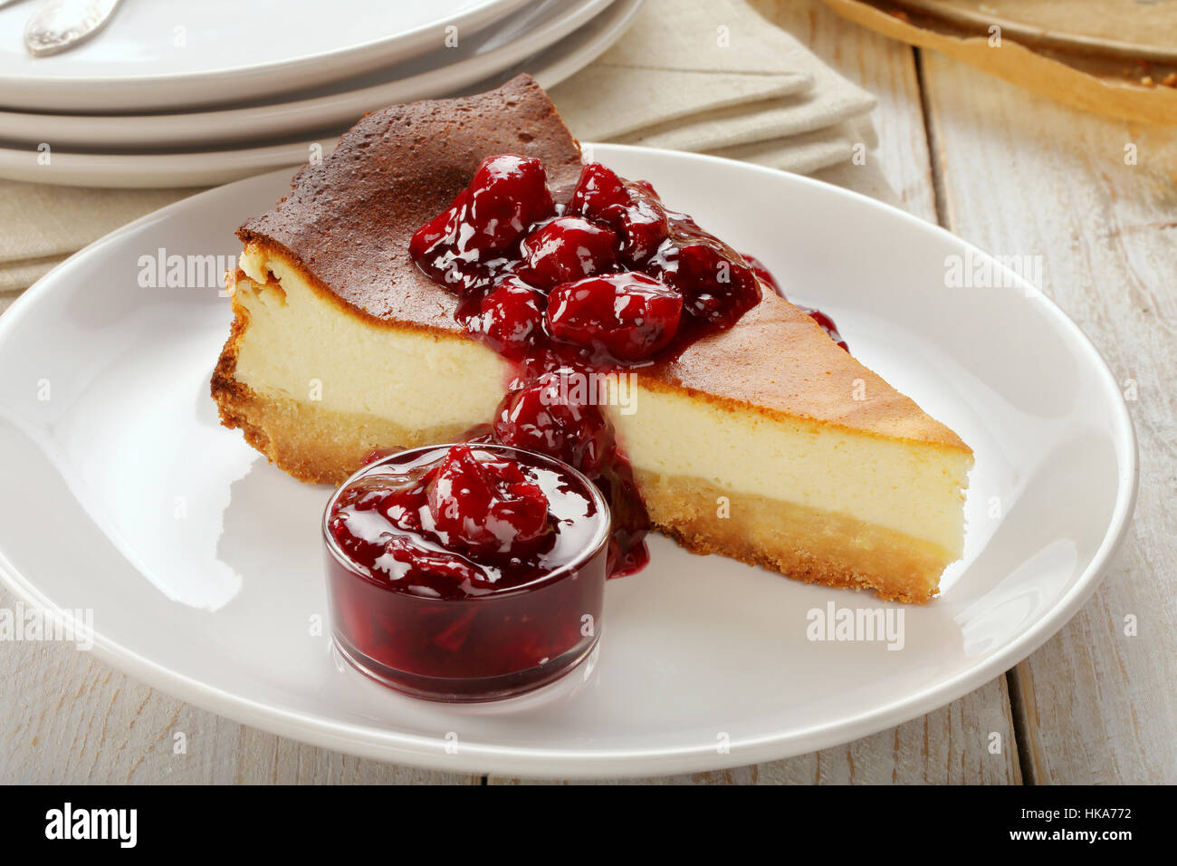 Cheesecake slice with cherry jam on wooden background Stock Photo