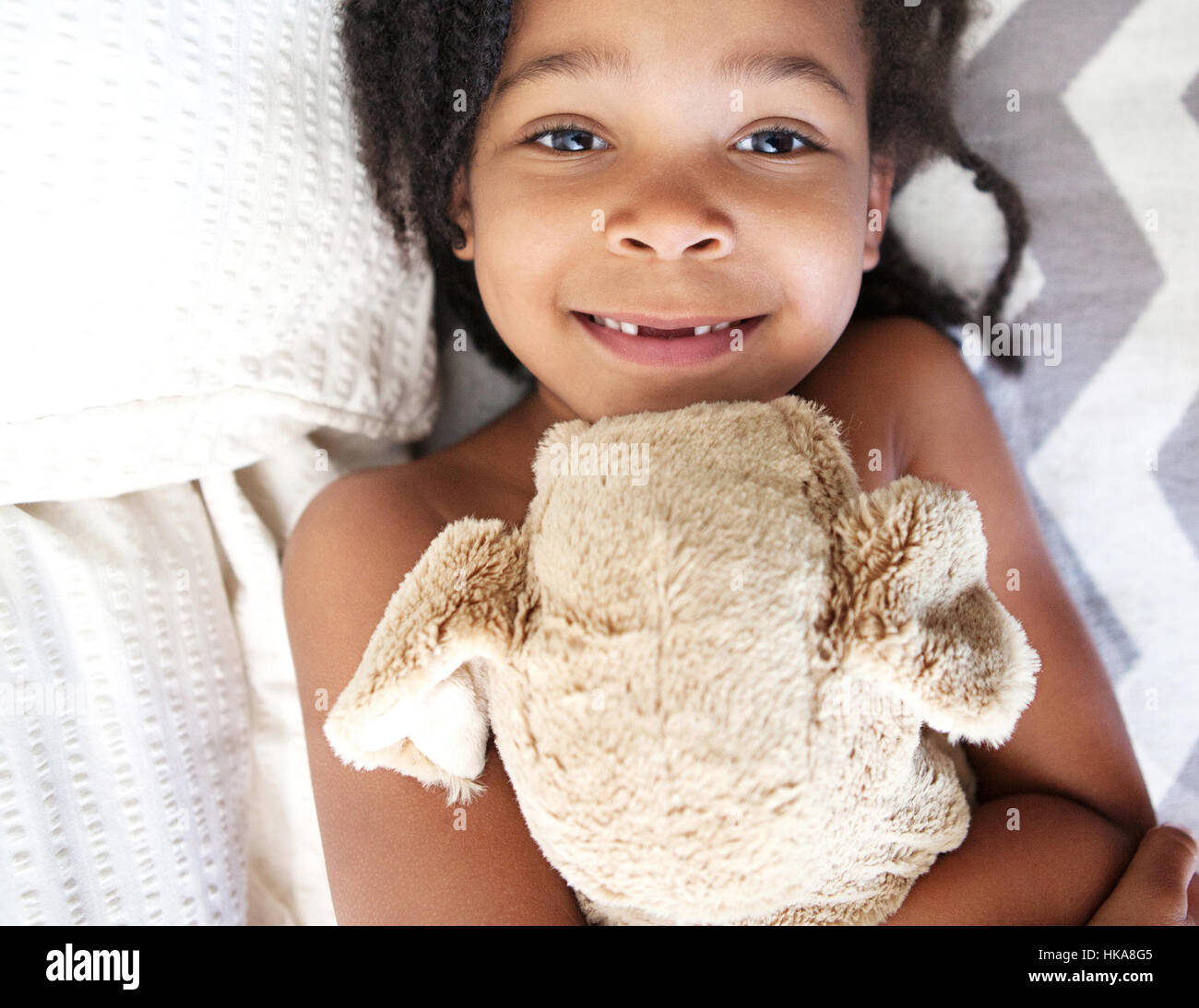 Little girl snuggles with teddy bear. Stock Photo