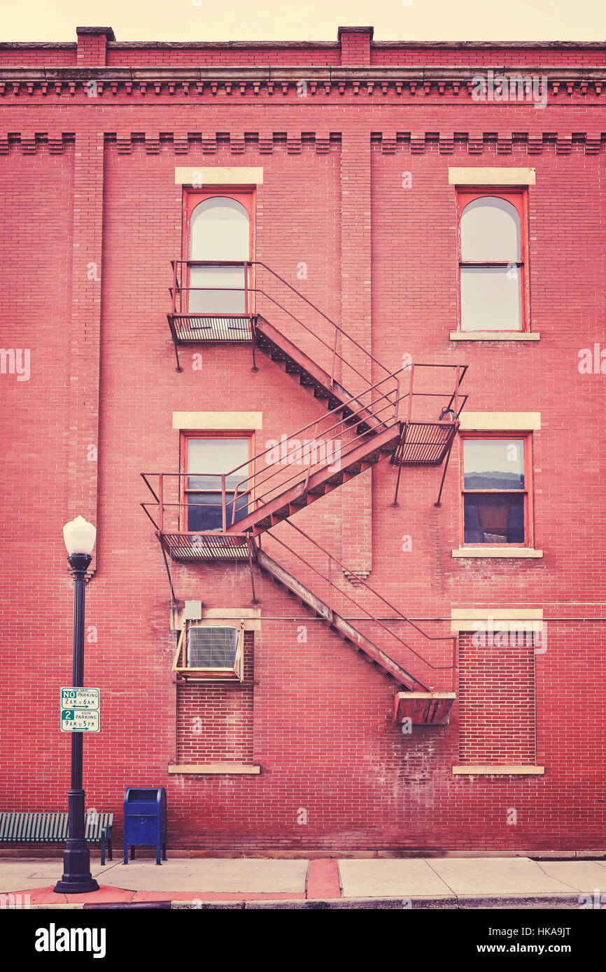 Color toned building wall with fire escape stairs, USA. Stock Photo