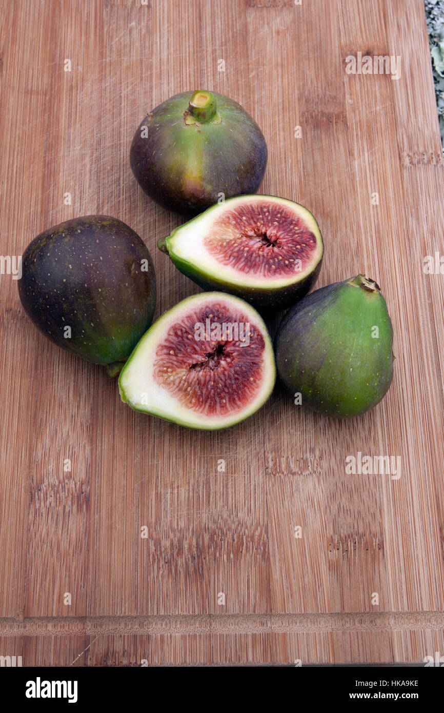 Fig fruits sliced in half on a chopping board Stock Photo