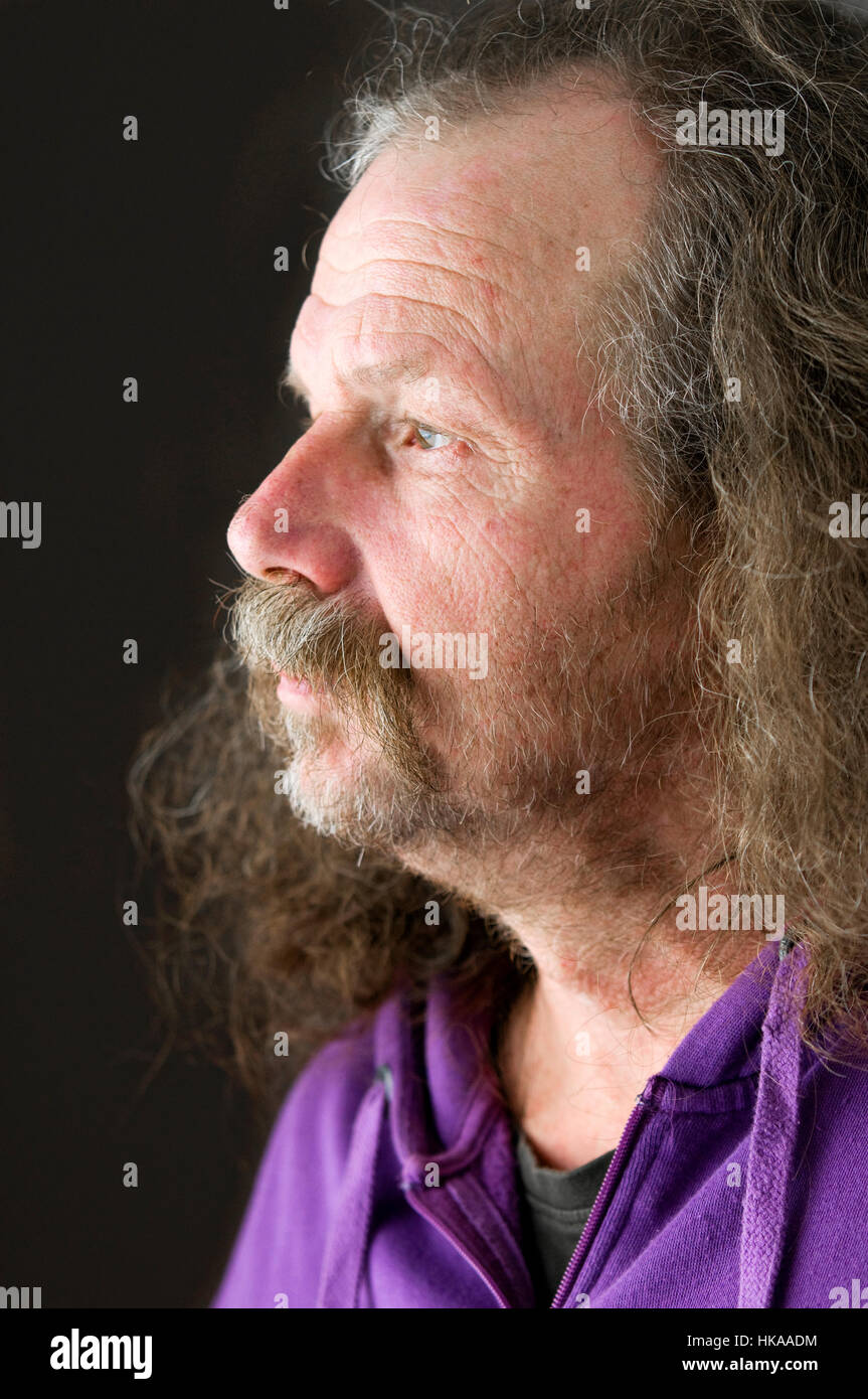 Lateral head portrait of an older man with a beard to the page in the light looking. Stock Photo