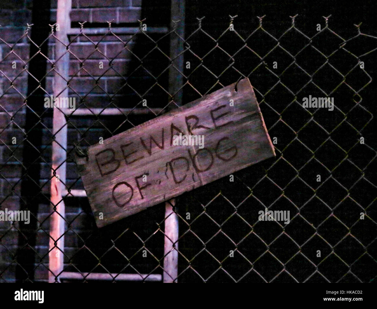 A Beware of the Dog sign on a wire fence Stock Photo