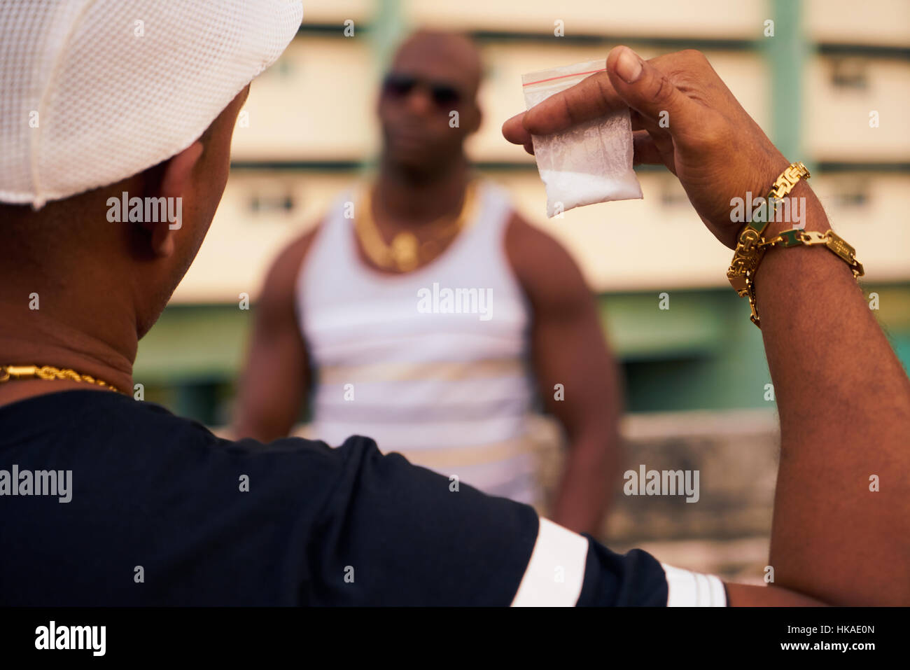 Substance abuse, crime, social issues, drugs. Hispanic and black gang members meeting and fighting over cocaine, heroin and money. Man selling drug do Stock Photo
