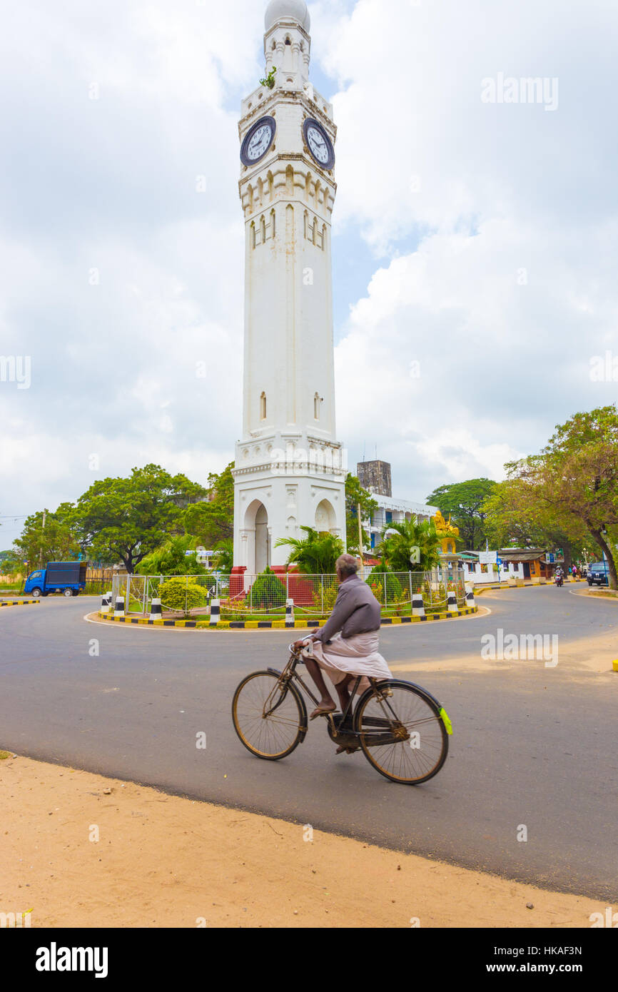 A Sri Lankan bicyclist enters the roundabout at the central clock tower Stock Photo