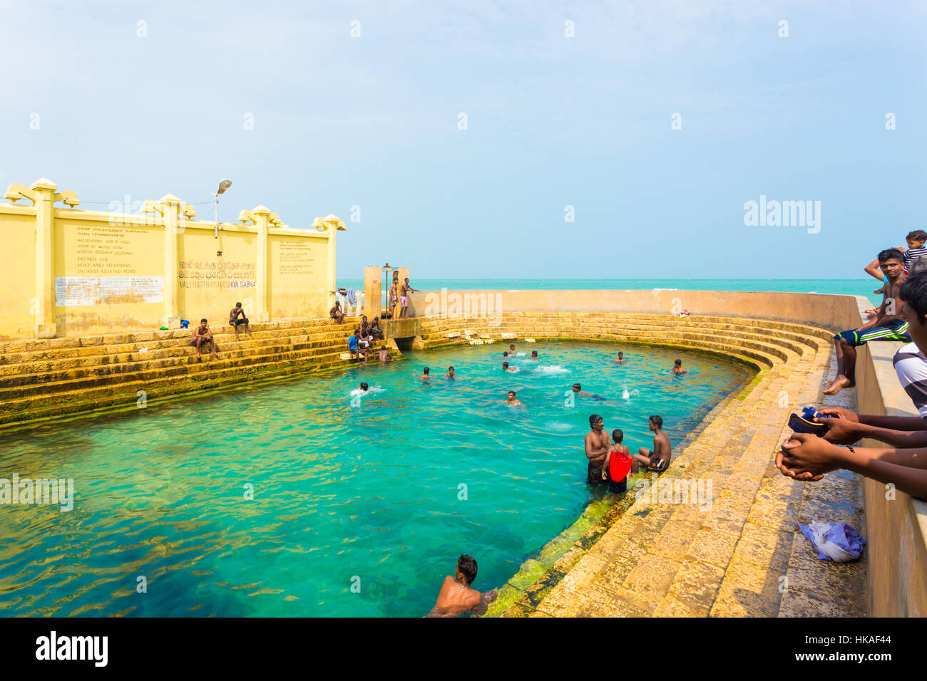 Sri Lankan swimmers enjoy the Keerimalai Hot Springs, a tourist attraction on the northern coast of Jaffna. Horizontal Stock Photo