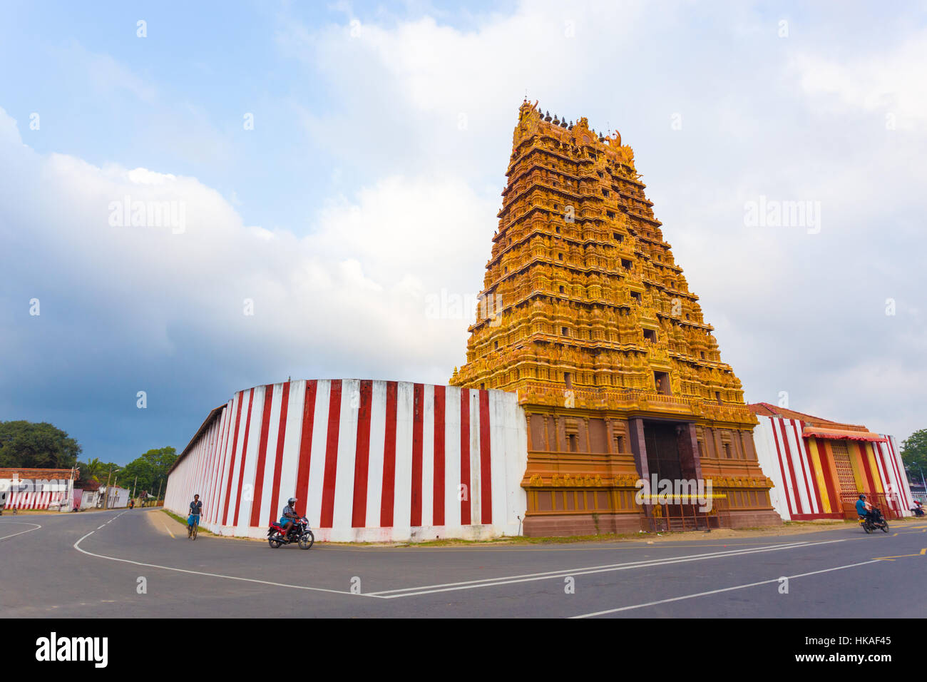 Sri Lankan people on the road in front of Golden Entrance gopuram tower, Swarna Vaasal, in Kandaswamy Kovil Temple in Nallur Stock Photo