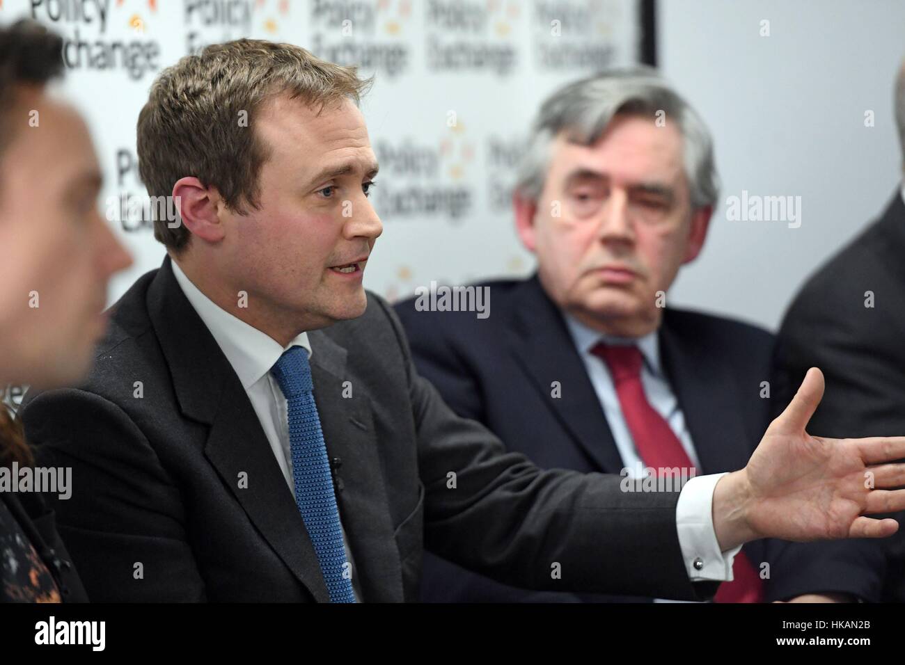 Tom Tugendhat MP is watched by former Prime Minister Gordon Brown (right) at the launch of a new bipartisan report titled The Cost of Doing Nothing, co-authored by the late Jo Cox MP, at the Policy Exchange in Westminster, London. Stock Photo