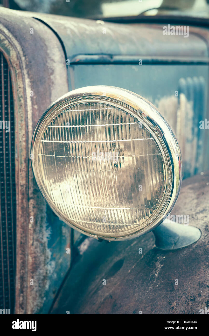 Color toned close up picture of an old rusty car headlamp, selective focus. Stock Photo