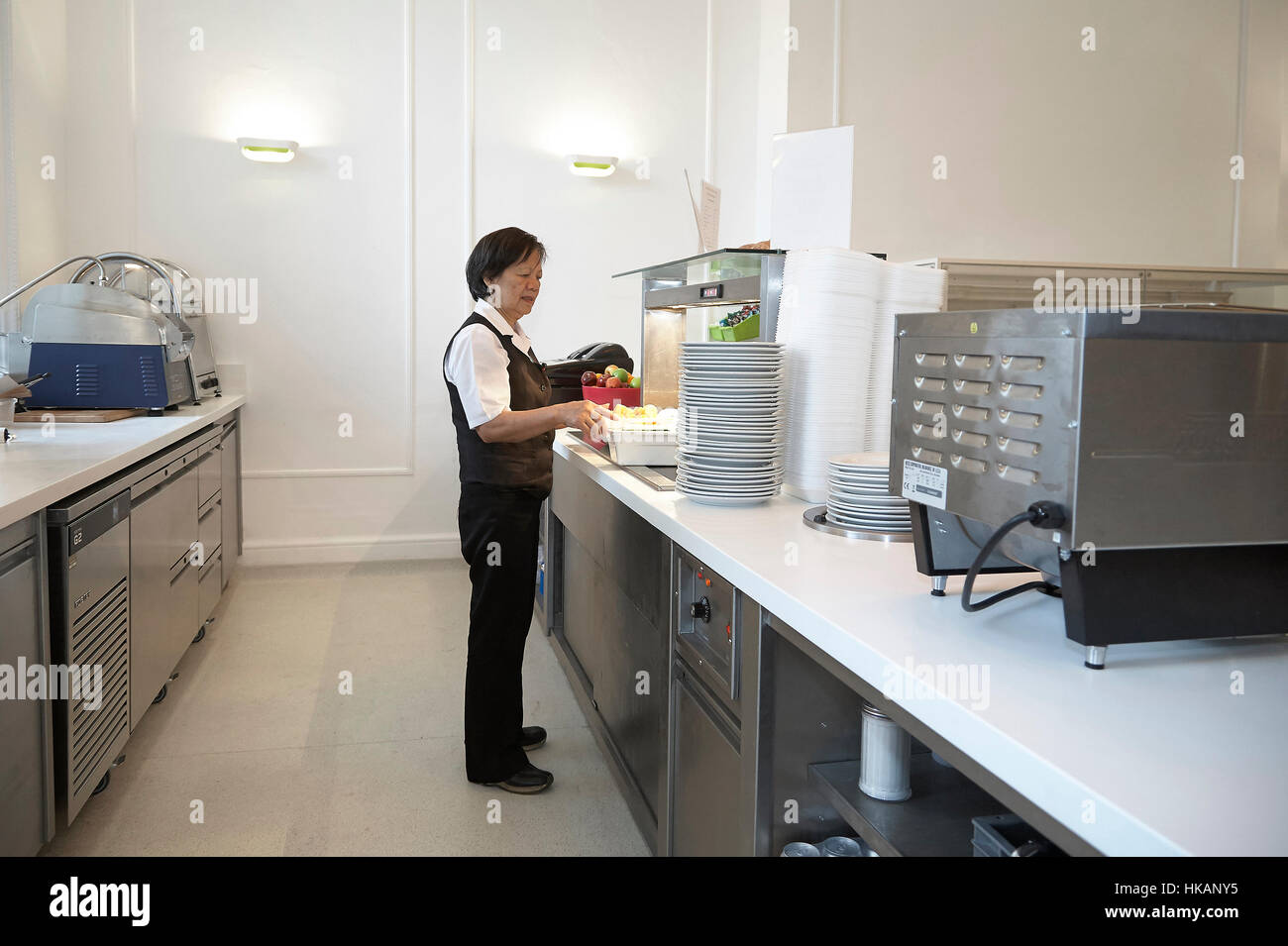 Canteen assistant preparing and serving food in a hospital Stock Photo