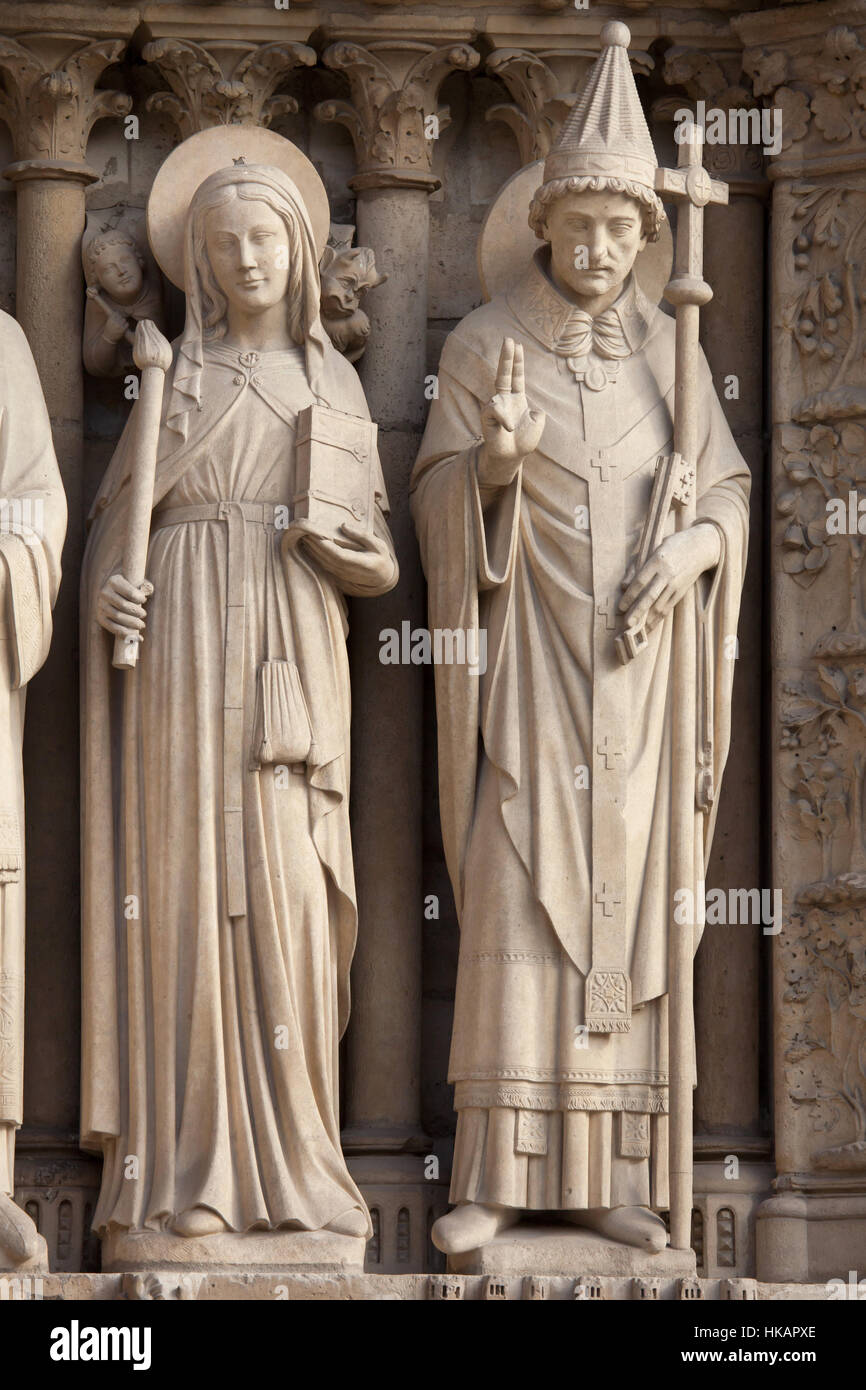 Saint Genevieve (L) and Pope Saint Sylvester I (R). Neo-Gothic statues on the main facade of the Notre-Dame Cathedral (Notre-Dame de Paris) in Paris, France. Damaged Gothic statues on the main facade were restored by French architects Eugene Viollet-le-Duc and Jean-Baptiste Lassus in the 1840s. Stock Photo