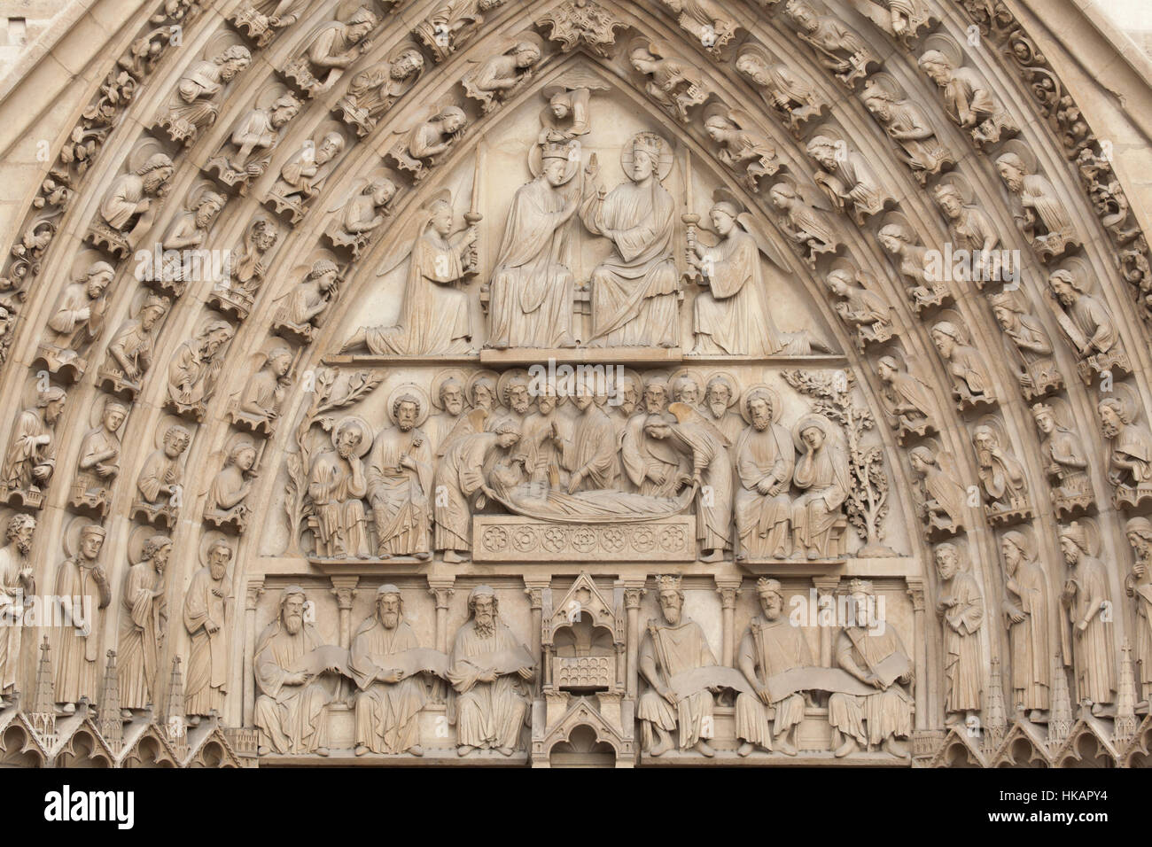 Coronation of the Virgin Mary, Dormition of the Virgin Mary and Three Prophets and Three Kings sitting beside the Ark of the Covenant (from top to bottom). Neo-Gothic tympanum of the portal of the Virgin Mary on the main facade of the Notre-Dame Cathedral (Notre-Dame de Paris) in Paris, France. The damaged Gothic portal was restored by French architects Eugene Viollet-le-Duc and Jean-Baptiste Lassus in the 1840s. Stock Photo