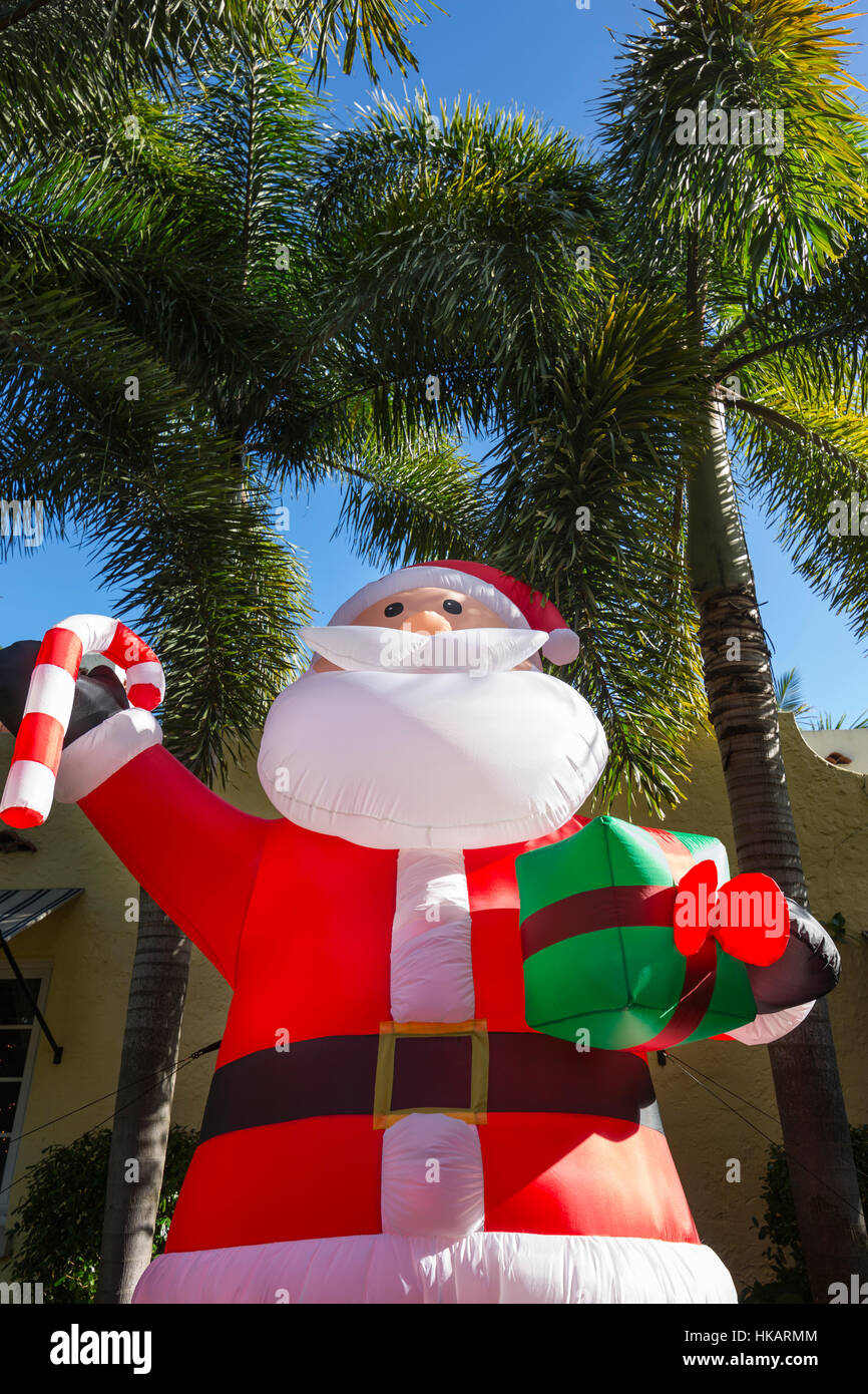 GIANT INFLATABLE SANTA CLAUS IN FRONT OF PALM TREES IN RESIDENTIAL FRONT YARD MIAMI FLORIDA USA Stock Photo