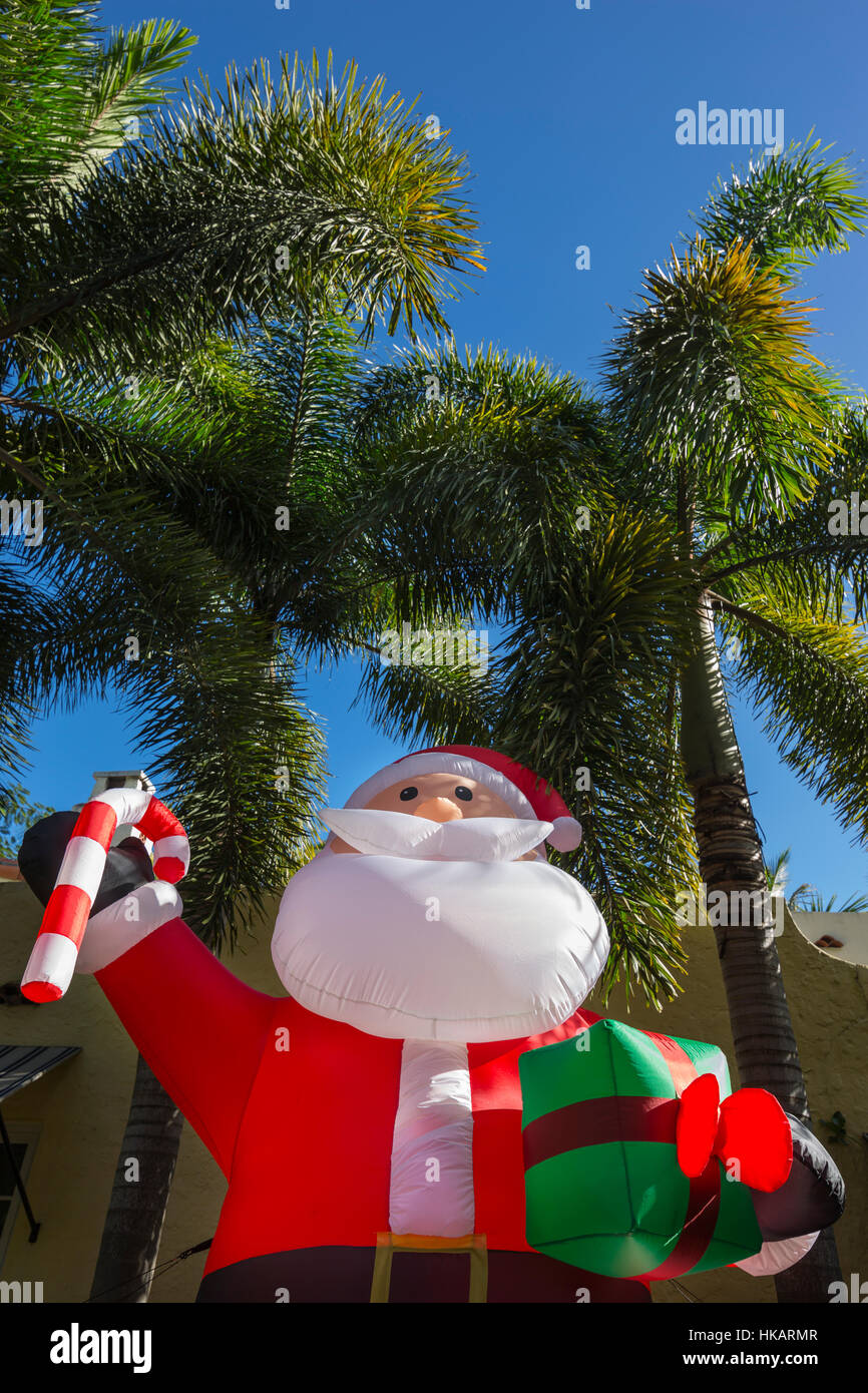 GIANT INFLATABLE SANTA CLAUS IN FRONT OF PALM TREES IN RESIDENTIAL FRONT YARD MIAMI FLORIDA USA Stock Photo