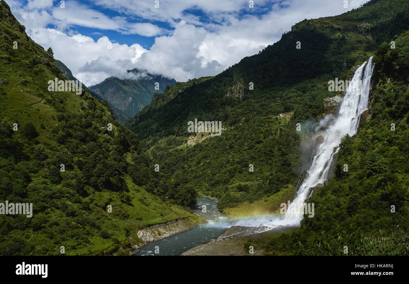 Waterfalls flow into the Kameng river in a deep valley surrounded by mountains of the Himalayas in Arunachal Pradesh, India. Stock Photo