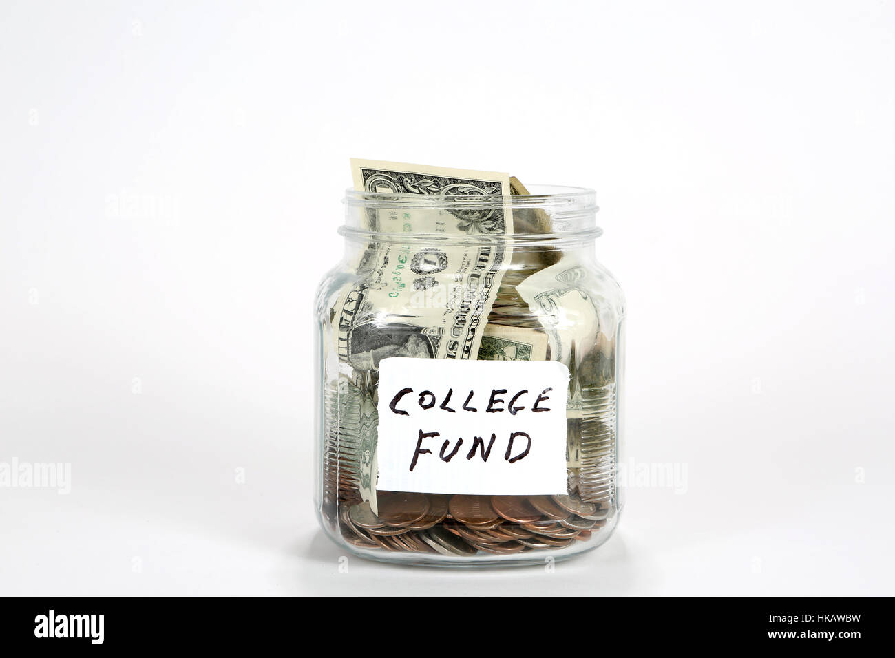 Glass jar filled with coins and paper money with a label written college fund. Stock Photo