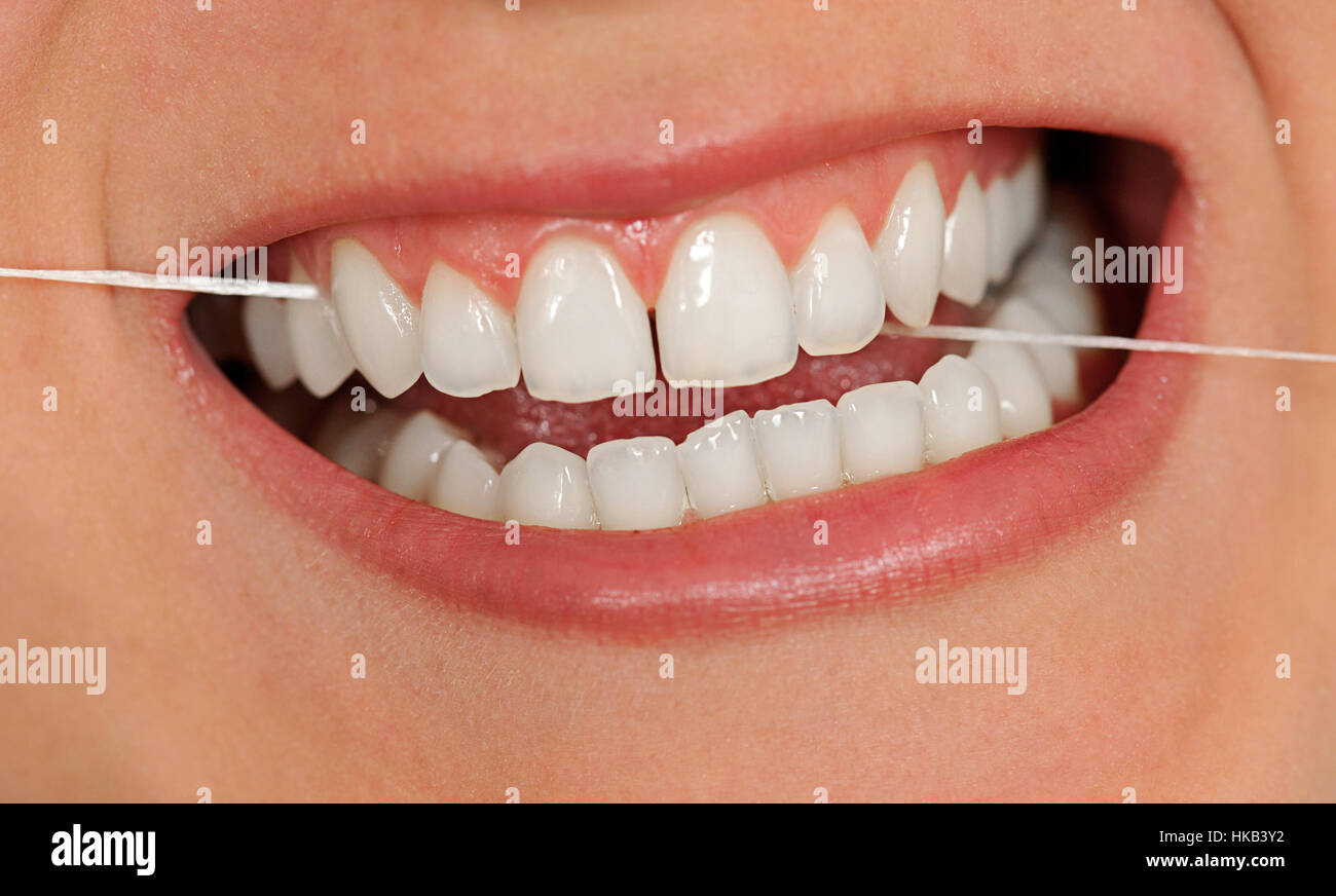 Cleaning teeth with dental string Stock Photo