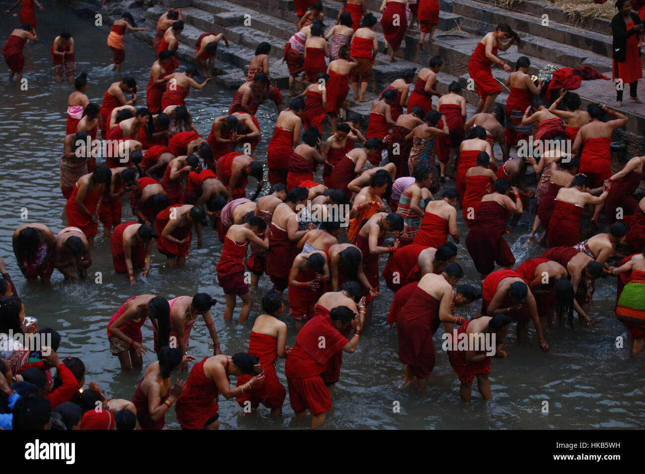 Kathmandu, Nepal. 27th Jan, 2017. Nepalese Hindu devotees return after taking a holy dip at Bagmati River during the month-long Swasthani Bratakatha festival at Pashupathinath Temple in Kathmandu, Nepal. Devotees recite Holy Scripture and women pray for the wellbeing of their spouses throughout the month-long fast. Credit: Skanda Gautam/ZUMA Wire/Alamy Live News Stock Photo