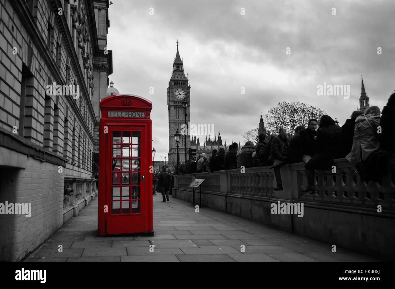 Selective color photo of a red telephone box in the city center of London, UK with the Big Ben in the background on Remembrance Day. Stock Photo
