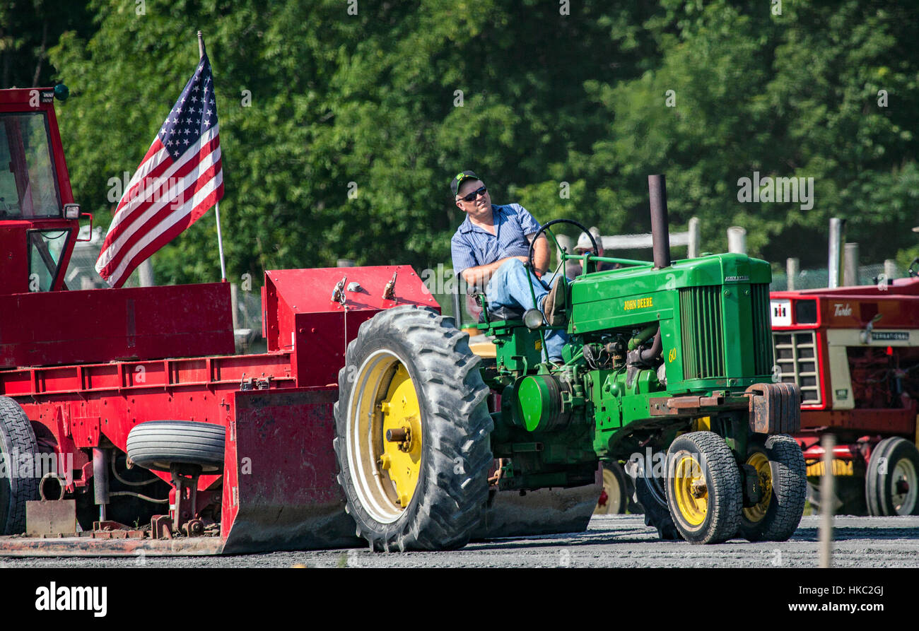 An antique John Deere tractor pulls a weighted sled at the annual fair in Bradford, Vermont, United States. Stock Photo