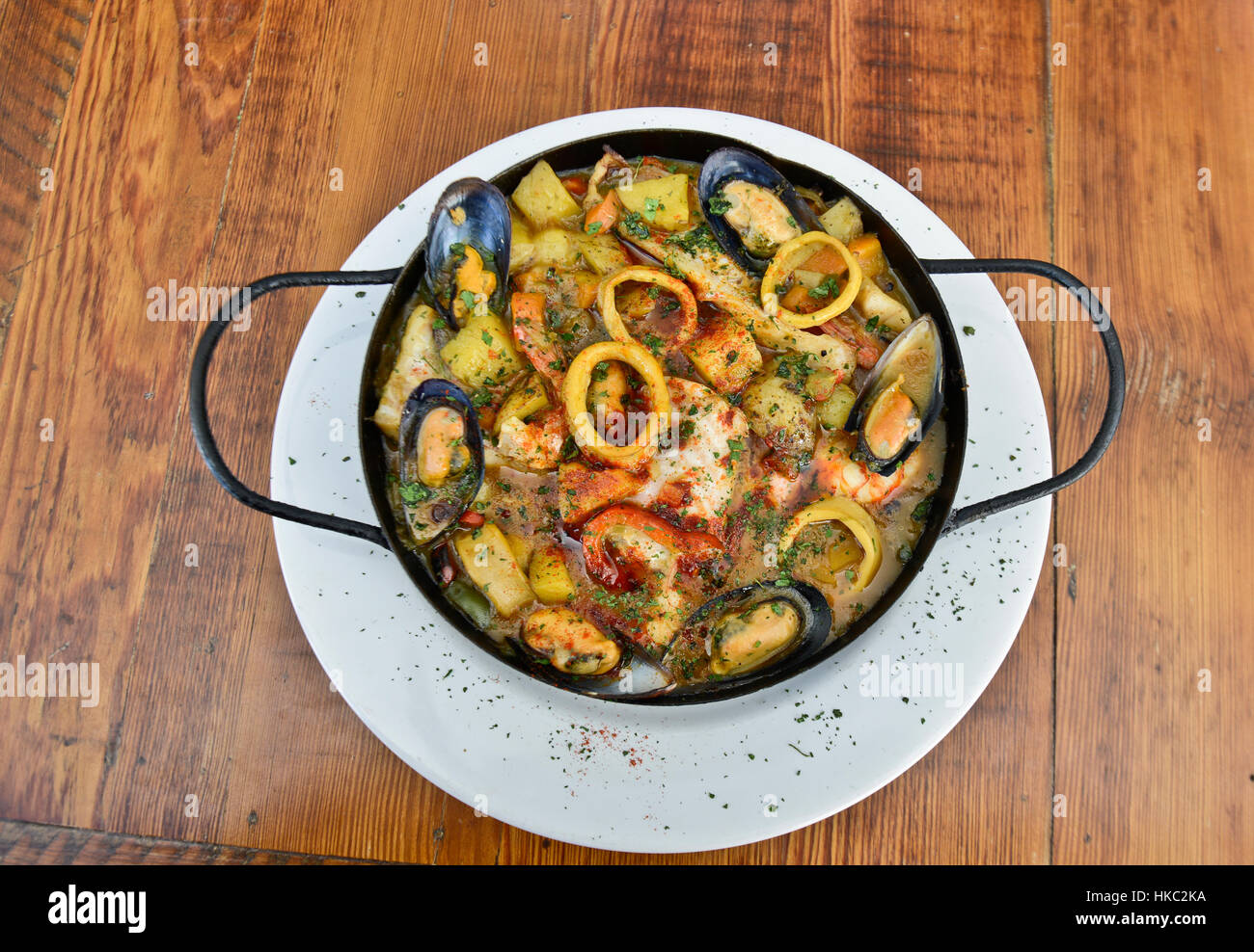 Traditional Spanish seafood stew (cazuela de mariscos) served on wooden table Stock Photo