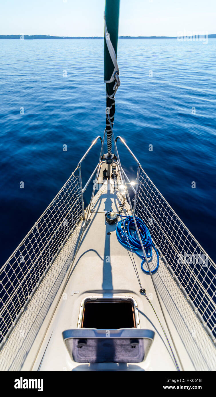 Front view of sailing boat on the sea. Bow side of yacht or sail boat gliding through calm sea in Adriatic sea on the sunny day. Stock Photo