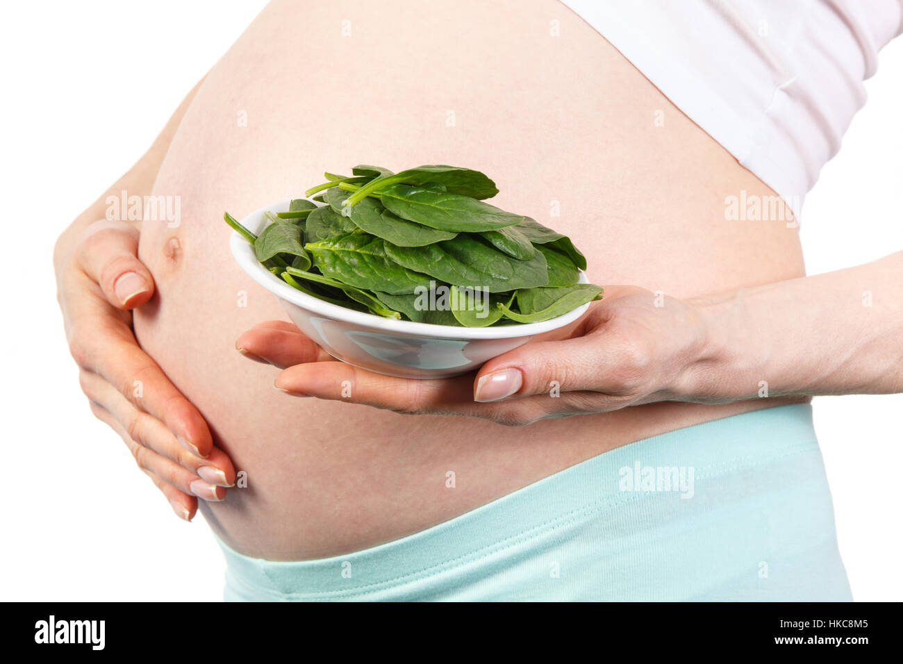 Pregnant woman with portion of fresh green spinach, concept of healthy