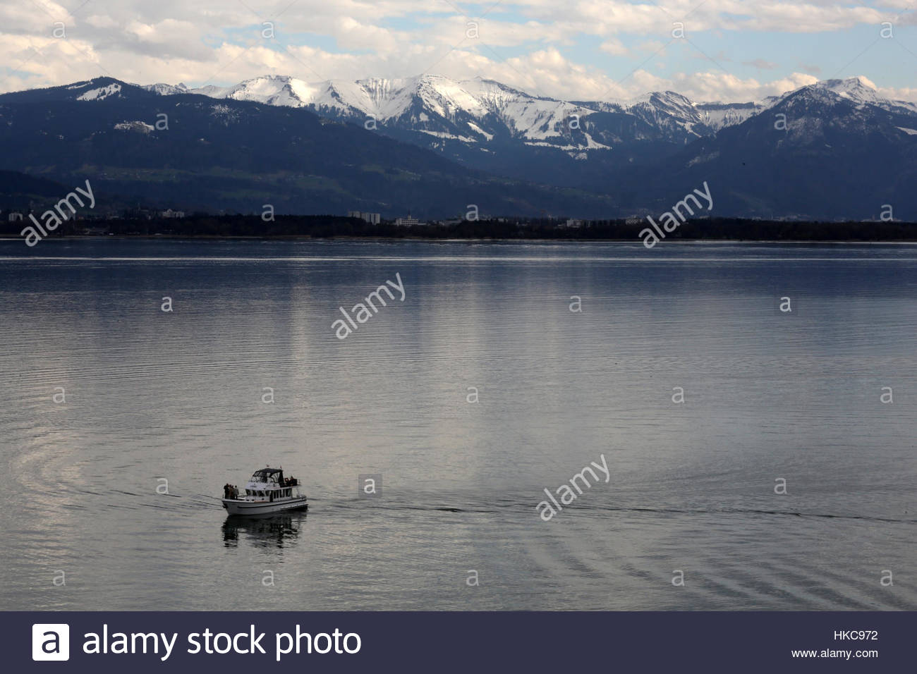 A boat on lake Constance with the snowy Alps in the background Stock Photo
