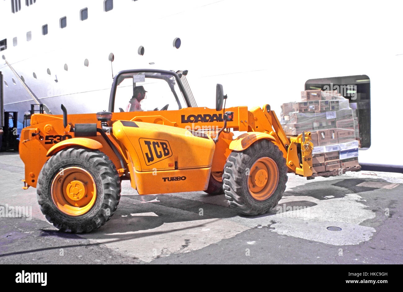 Cruise ship liner at Charlotte Amalie port in St Thomas in US Virgin Islands Caribbean hold loaded with provisions by JCB fork lift truck and driver Stock Photo