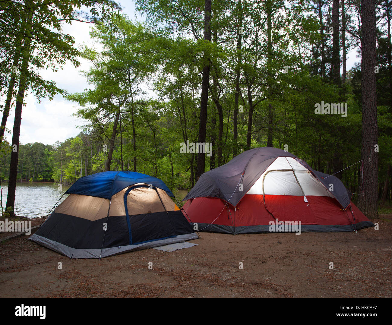 Two tents pitched by a lake with nightfall soon to arrive Stock Photo