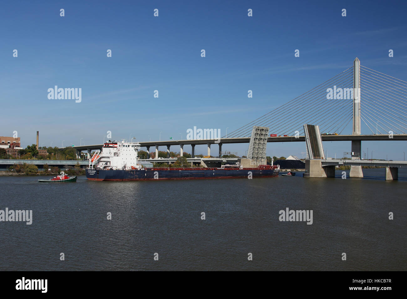 Great Lakes Freighter, Algoma Equinox, St Cathrines, being maneuvered by tug boats through draw bridge at the Maumee River, Toledo, Ohio, USA. Stock Photo