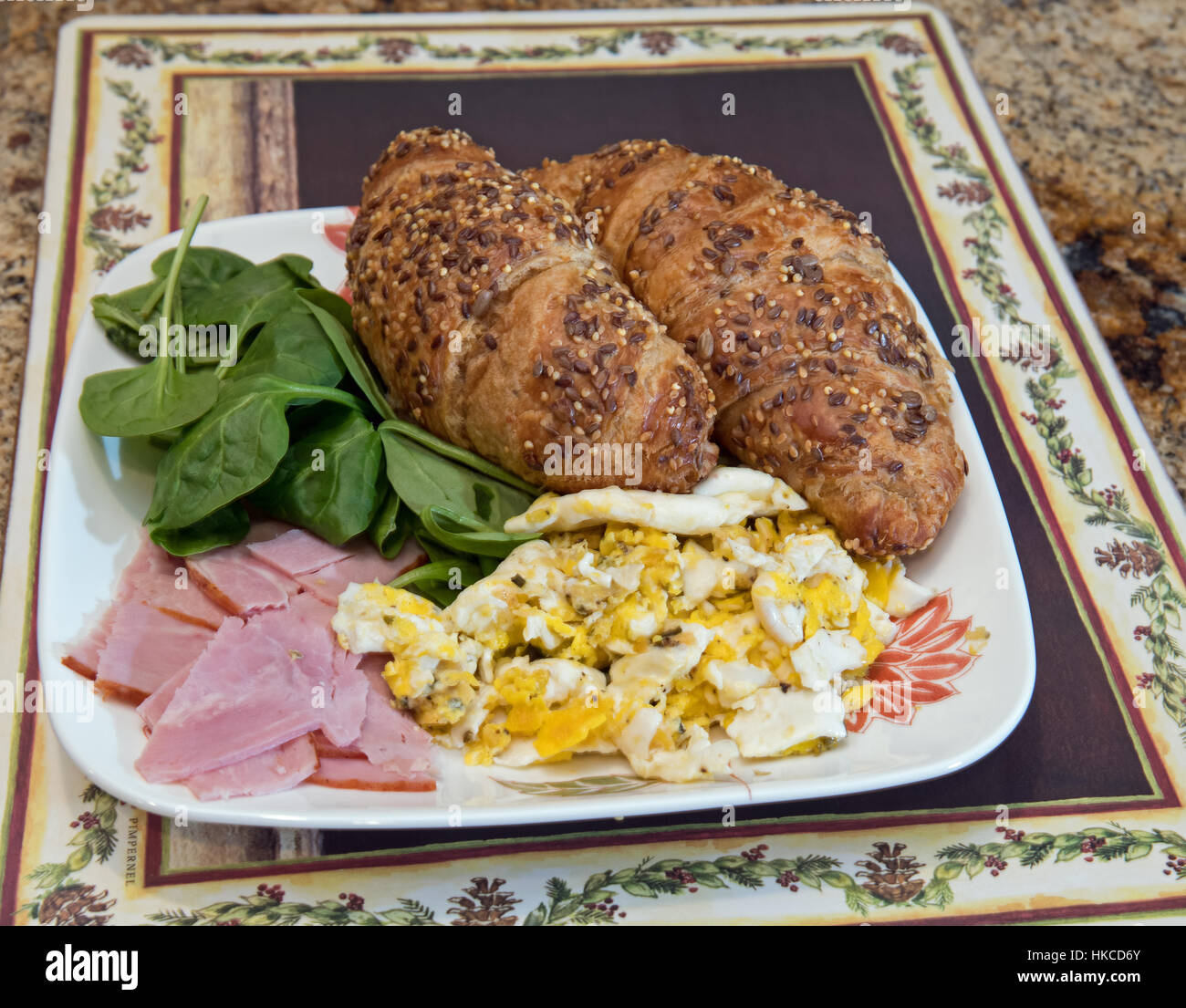 Plate of ham, eggs, croissants and spinach Stock Photo