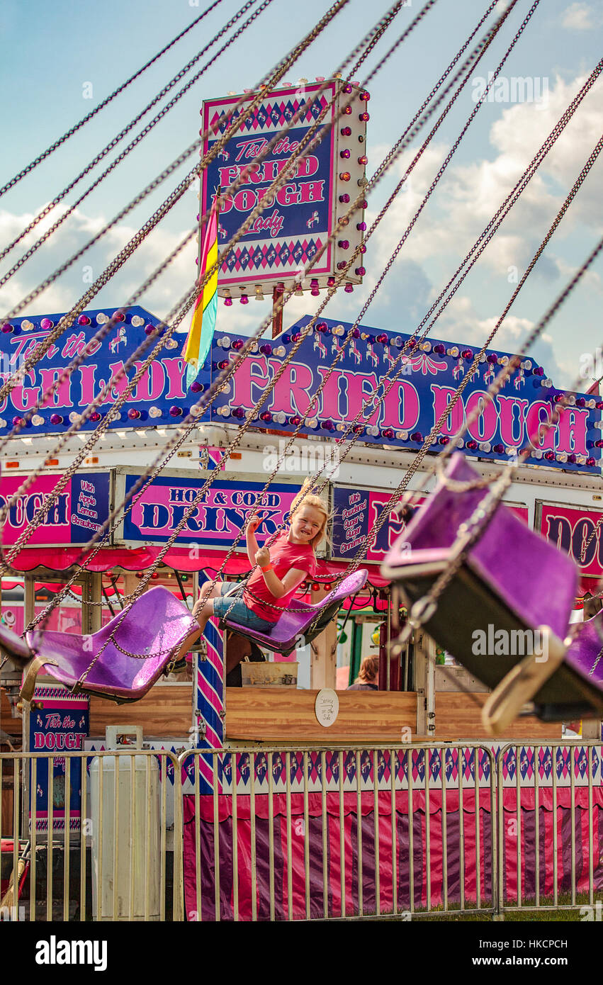 A little girl enjoys the flying chair ride at the Connecticut County Fair in Bradford, VT, USA. Stock Photo