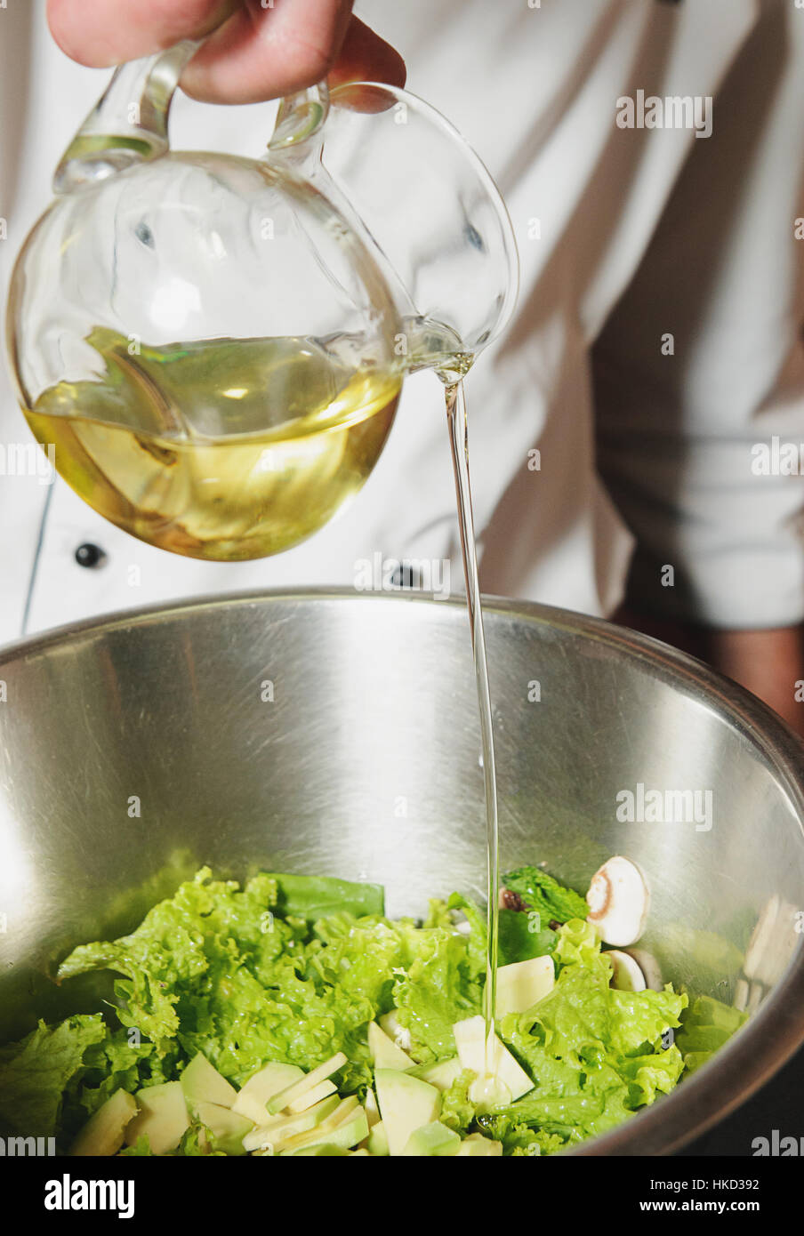 chef adding oil in vegetarian salad Stock Photo