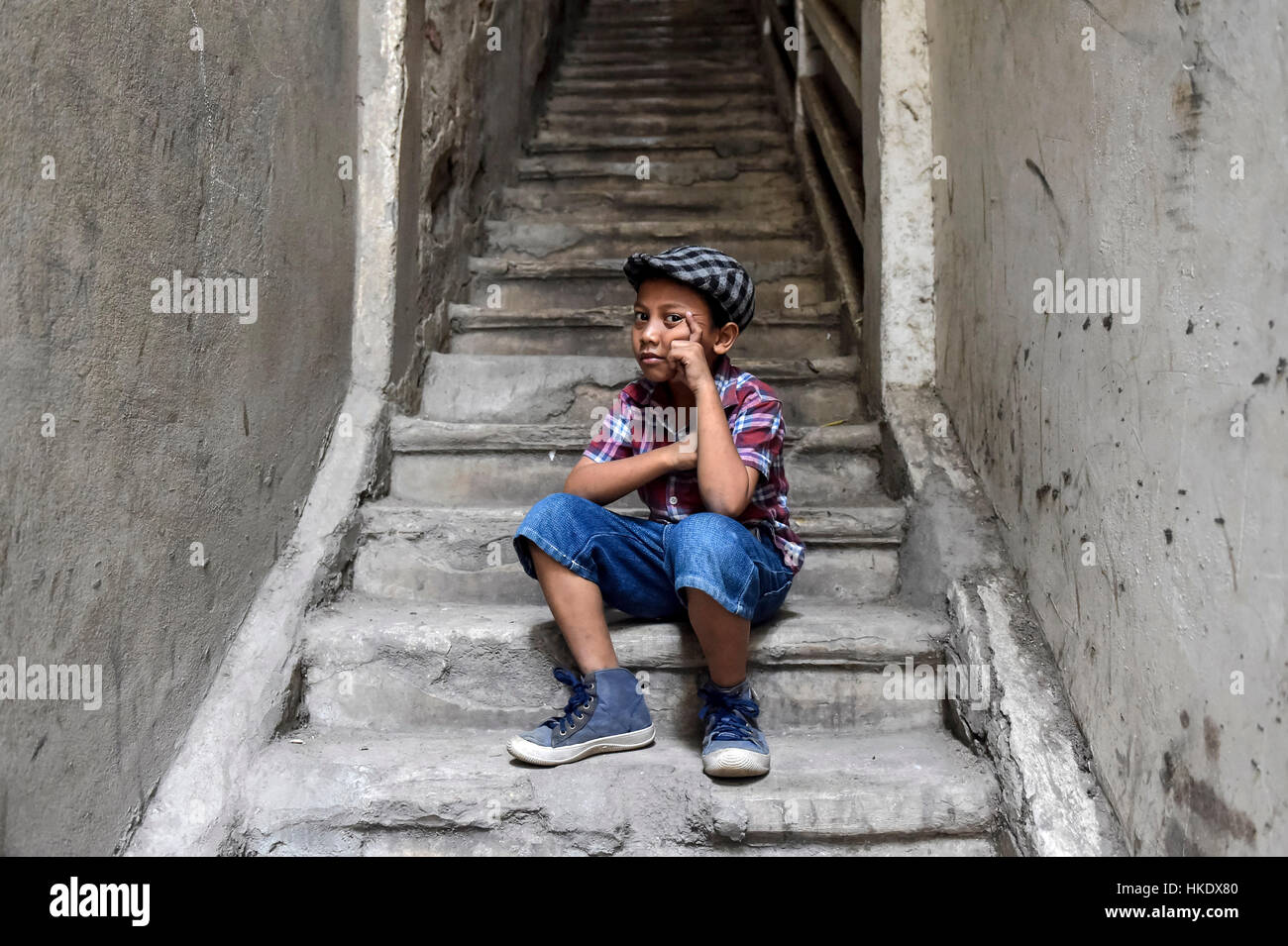 Boy on staircase with shirt and flat cap, Phnom Penh Province, Cambodia Stock Photo