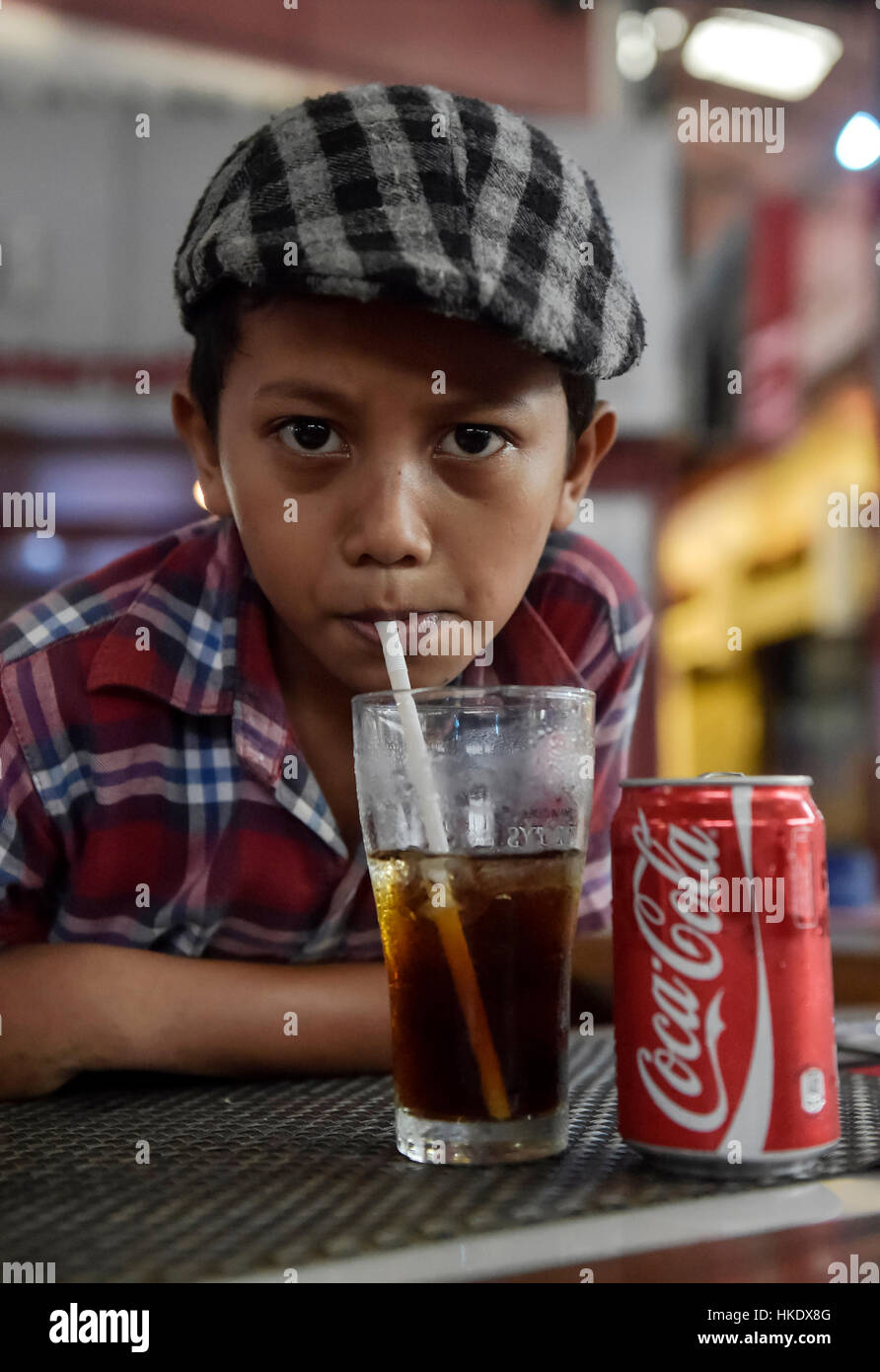 Boy drinking a Coke with a straw, Phnom Penh Province, Cambodia Stock Photo
