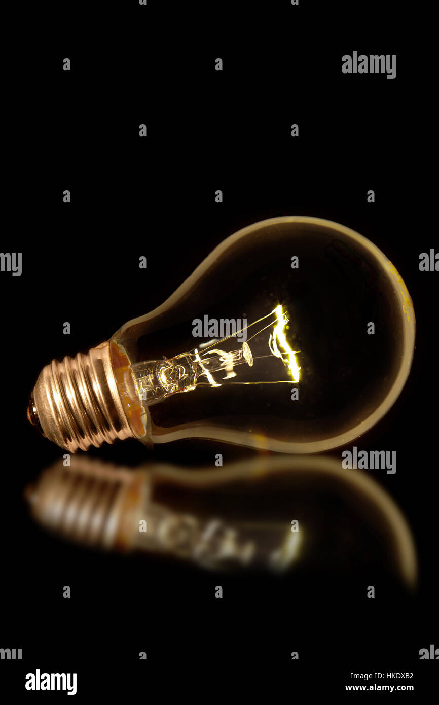 Glowing lightbulb with reflection Stock Photo