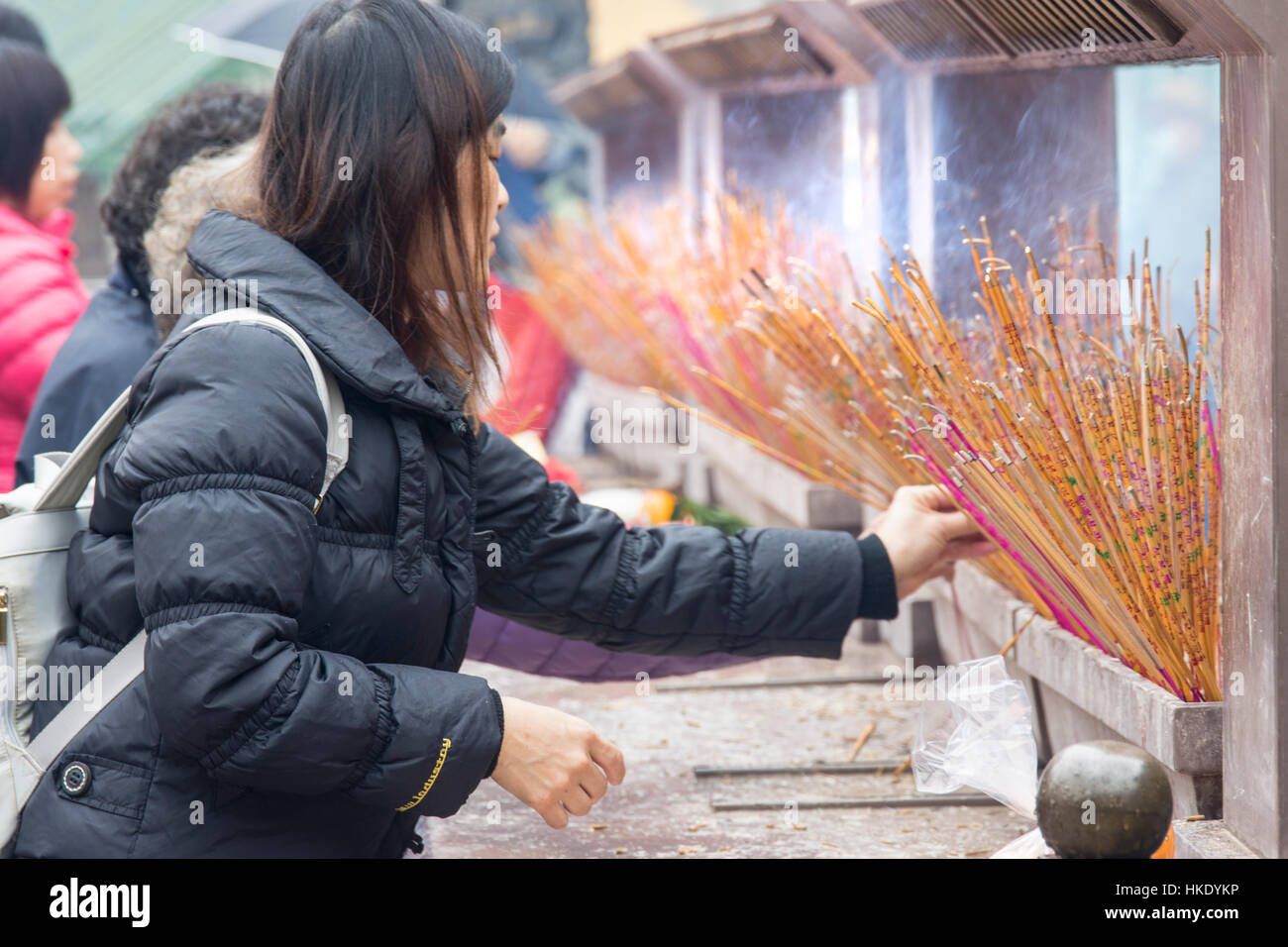 faithful in prayer while offering incense sticks in  Sik Sik Yuen Wong Tai Sin temple in Hong Kong Stock Photo
