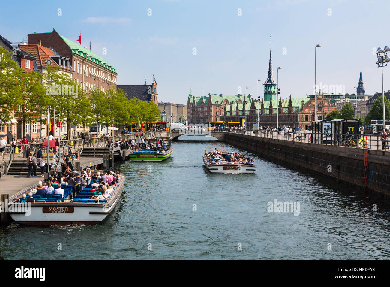 COPENHAGEN, DENMARK - MAY 24, 2016: Tourists enjoy the traditional architecture from a tourist boat along the canals of Denmark capital city on a sunn Stock Photo