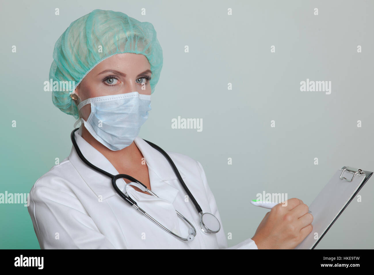 Female doctor in a white coat wearing hair bonnet and mouth guard
