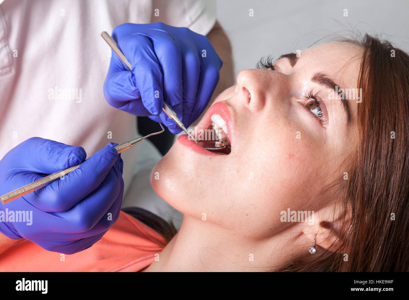 dentist checks gums and teeth of his patient with mirror and probe