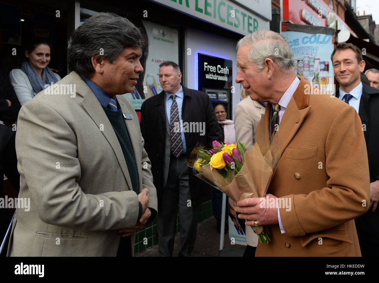 The Prince of Wales receives flowers from the owner of a pharmacy