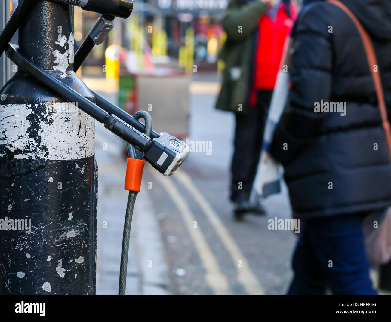 Broad Street, Oxford, United Kingdom, January 22, 2017: U-lock secure bicycle locks on light post on Broad street, Oxford city centre, England Stock Photo