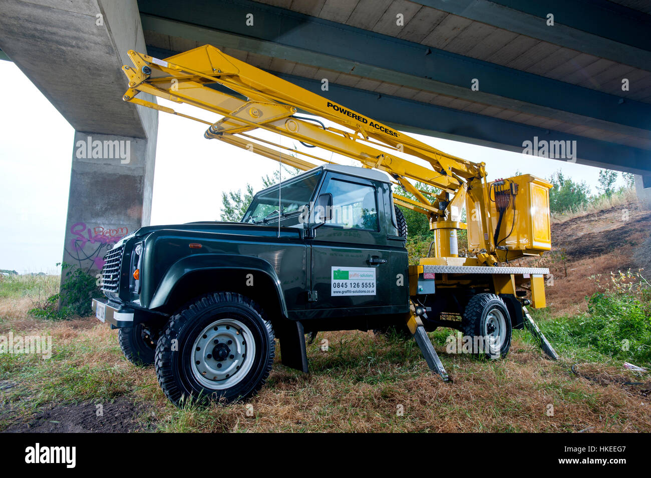 Working Land Rover Defender fitted with a high access lift cherry picker Stock Photo