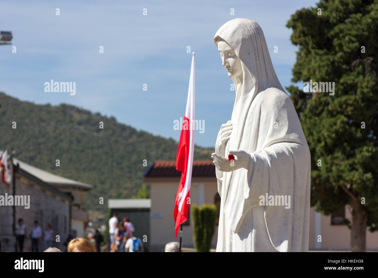 MEDJUGORJE, BOSNIA AND HERZEGOVINA, 2016/08/20. The statue of Virgin Mary in front of the church of Saint James. She is inviting her children to pray. Stock Photo