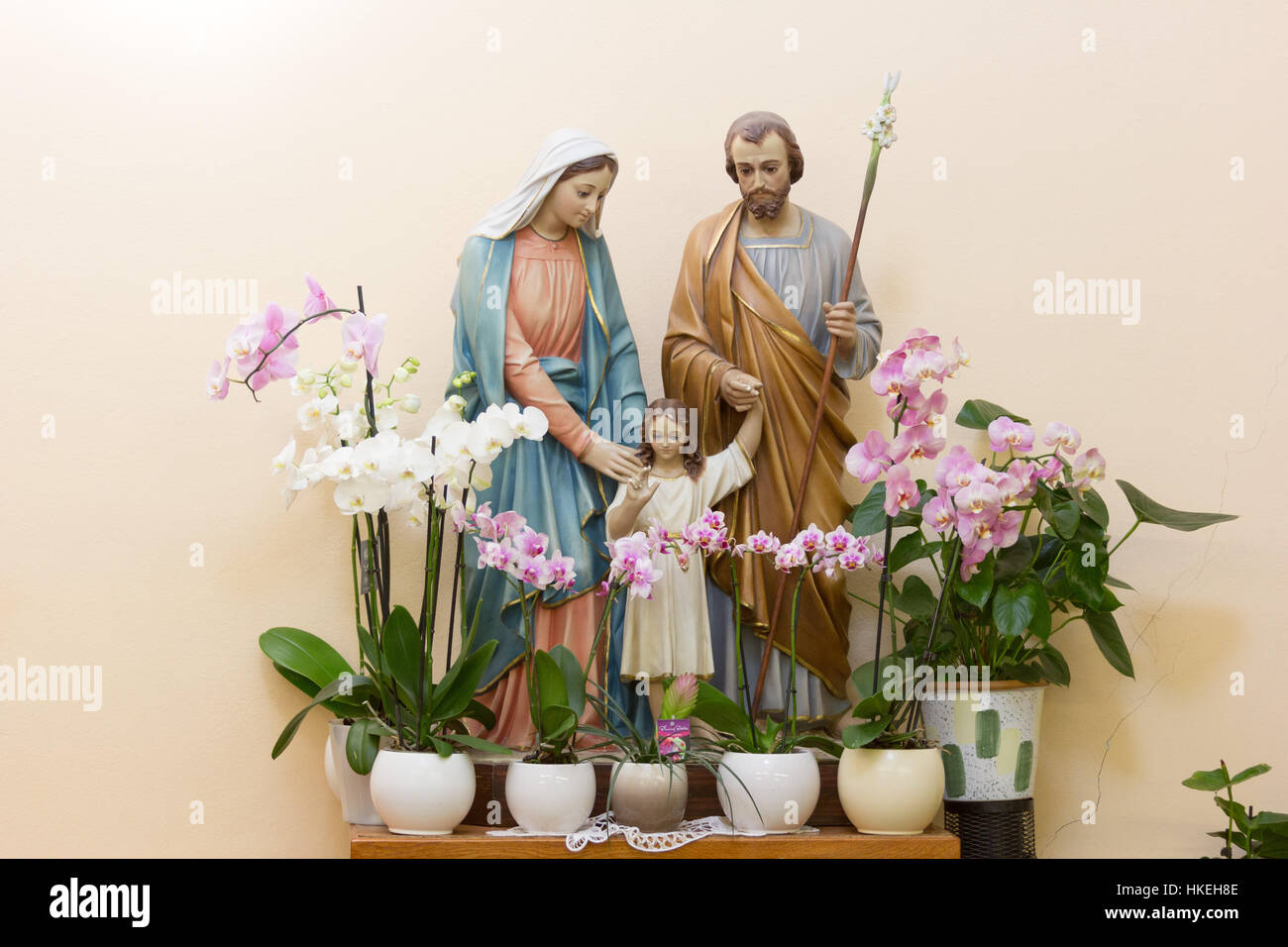 MEDJUGORJE, BOSNIA AND HERZEGOVINA, August 21 2016. The statue of the Holy family - Jesus, Mary and Joseph surrounded by white and pink orchids. Stock Photo