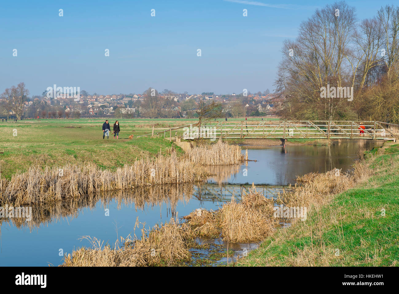 Sudbury Suffolk, a couple approach a bridge over the River Stour in the water meadows near Sudbury in Suffolk, Babergh district, UK. Stock Photo