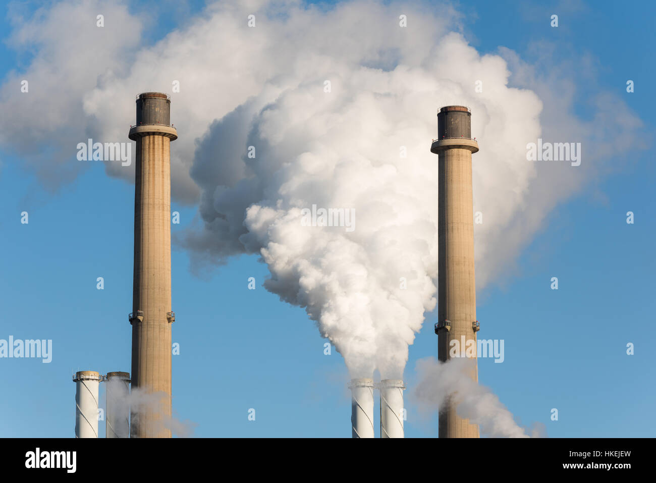 The pipes of a factory with white smoke as a global warming concept. Stock Photo