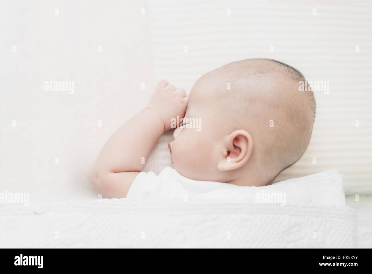 Asian little infant baby boy sleeping on soft white blanket in bed. Stock Photo